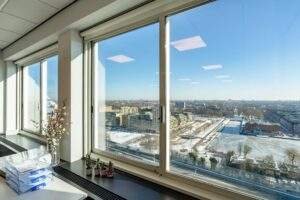 Uitzicht vanuit een hoog kantoor op het besneeuwde Koningin Wilhelminaplein in Amsterdam.
